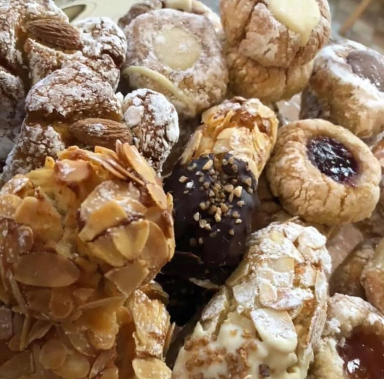 Nahaufnahme von Mandel- und Mürbegebäck mit Puderzucker, Mandelblättchen und Schokoglasur